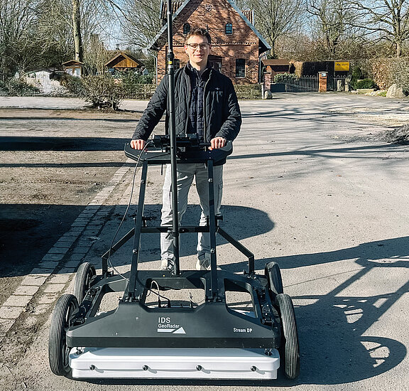 Für ein Praxisprojekt hat Oliver Potthoff mittels eines Geo- Radars Straßenabschnitte auf Leitungen, Wurzeln oder Altlasten geprüft, um zu untersuchen, ob damit auf die im Leitungsbau üblichen Querschläge verzichtet werden kann. (Foto: © FH Münster/Oliver Potthoff) 	